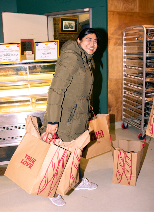 A volunteer carrying bags of donated food